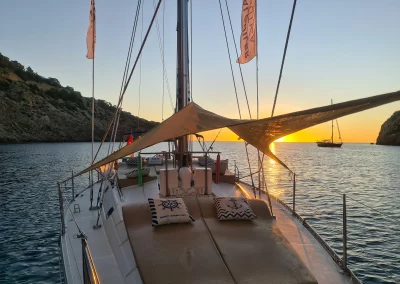Velero NavegaMed de Santa Pola fondeado al amanecer en cala llonga de ibiza
